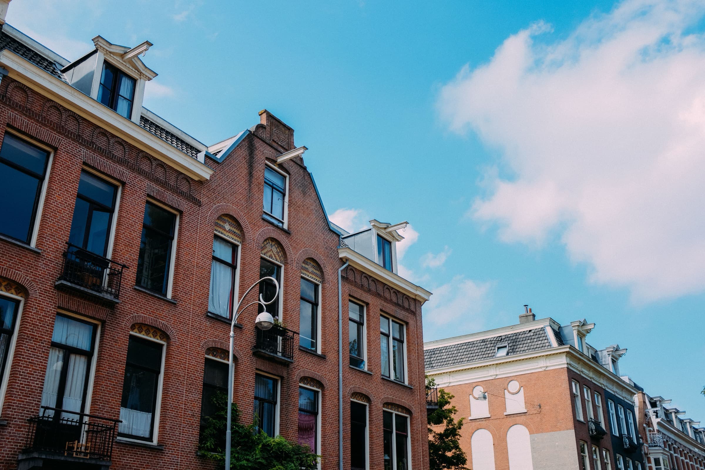 Bakstenen gevels met dakkapellen onder een blauwe lucht
