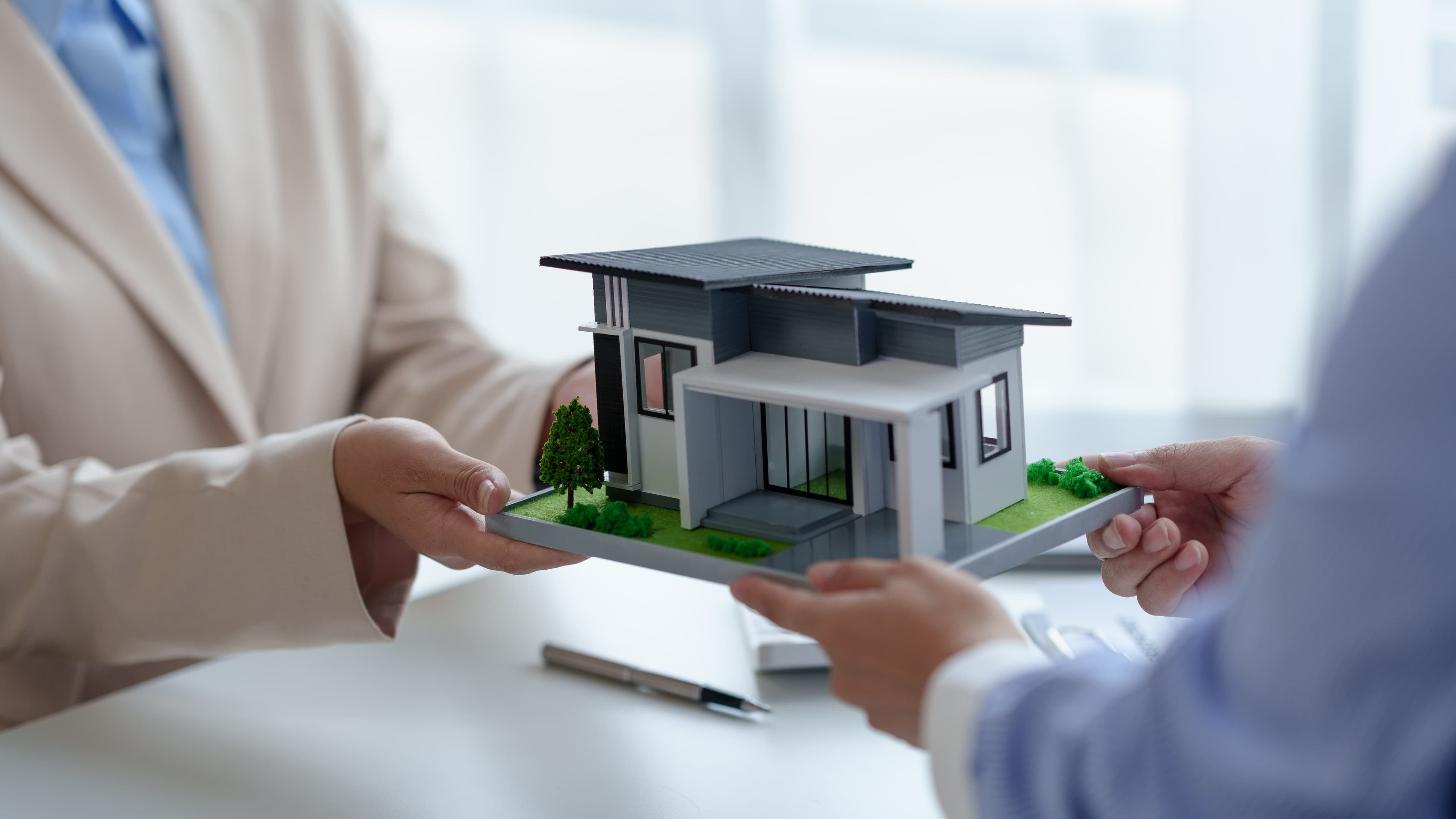 Adviesgesprek met een maquette van een woning